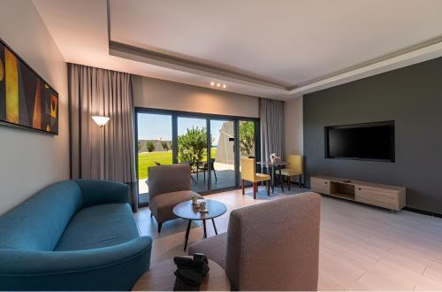 a living room with a blue couch and a tv at HDB Al Khobar Resort & Spa in Al Khobar