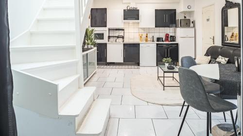 une cuisine et un salon avec une table et des chaises dans l'établissement Smart Confort 10 - Appartement confort et stylé, à Troyes
