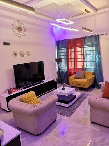 a living room with couches and a flat screen tv at YAYA in Cotonou