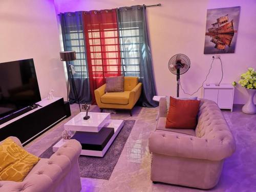 a living room with two couches and a tv at YAYA in Cotonou
