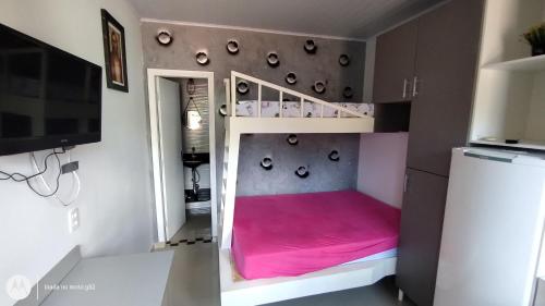 Quitinete compacta في باليريو كامبوريو: غرفة نوم مع سرير بطابقين مع مرتبة وردية