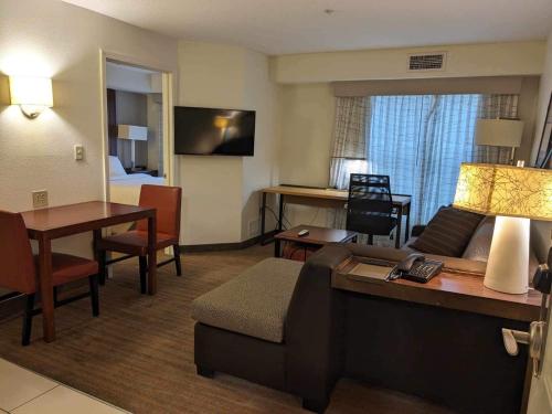 een hotelkamer met een bank en een woonkamer bij ReVi Columbus North in Columbus