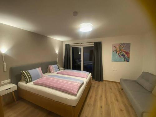 een kleine slaapkamer met een bed en een bank bij Appartement Tannenhof I in Ramsau am Dachstein