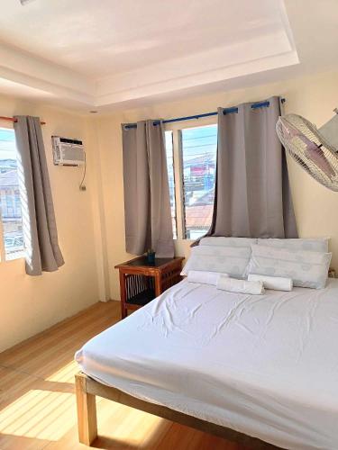 a bedroom with a white bed and a window at Pangandoy Homestay in General Luna