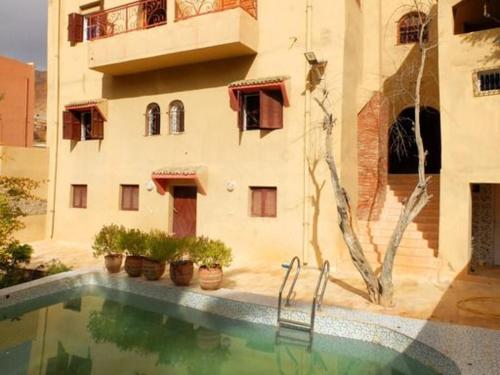 a house with a swimming pool in front of a building at Gite TALBOURINE in Taroudant