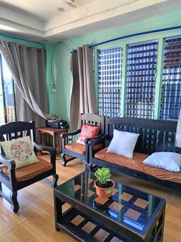 a living room with couches and chairs and a table at Pangandoy Homestay in General Luna