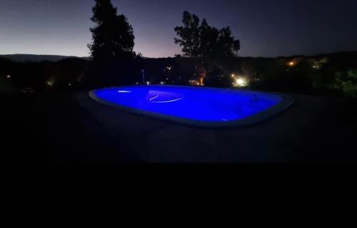 a blue swimming pool in the dark at night at El Inti in San Fernando del Valle de Catamarca