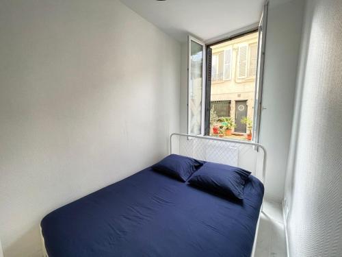 a small bedroom with a blue bed and a window at Appartement cosy aux portes de Paris in Alfortville