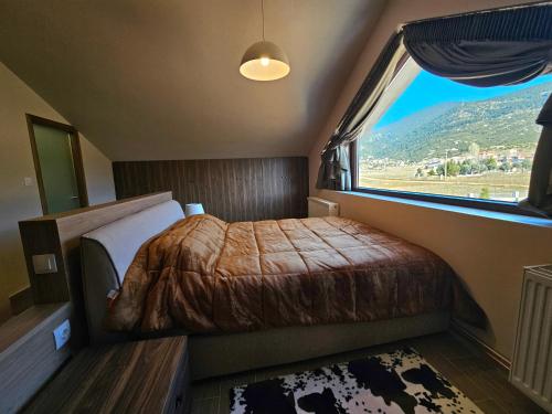 ein Schlafzimmer mit einem Bett und einem großen Fenster in der Unterkunft Kallisto villas in Kalívia