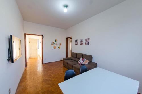 ein Wohnzimmer mit Sofa und Fernseher in der Unterkunft Estação 3 qtos - Vista cartão postal - BHSH in Belo Horizonte