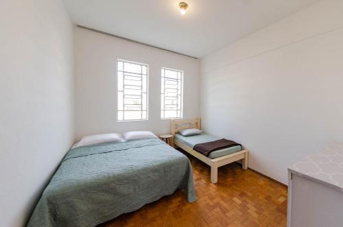 a bedroom with a bed and a bench in it at Apto 3qts centro - vista cartão postal in Belo Horizonte