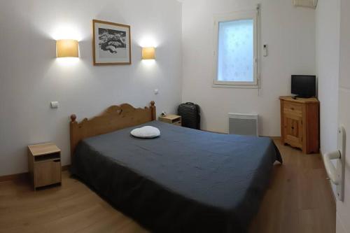 une chambre avec un lit, une télévision et une fenêtre dans l'établissement L'APPARTEMENT DE NOAH appartement Rez de chaussée classé 2 étoiles avec terrasse, à Ax-les-Thermes