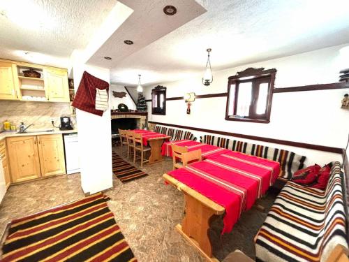 Guest House Meraklii في Smilyan: غرفة مع طاولات وكراسي في مطبخ