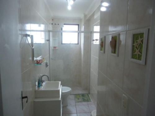 a white bathroom with a sink and a shower at Dom Pedro 54 in Guarujá