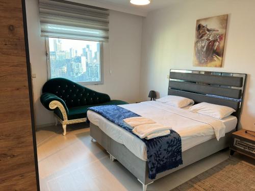 a bedroom with a bed and a chair and a window at Flora Rezidance Ataşehir in Istanbul