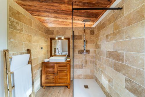 uma casa de banho com um chuveiro e um lavatório. em Bungalow L'escale de Takamaka em Saint-Benoît
