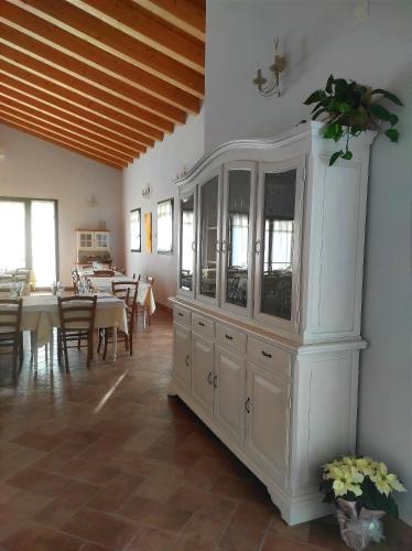 a large white cabinet in a dining room with tables at Agriturismo Honey Farm in Piazzola sul Brenta