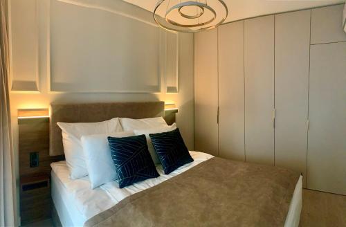 a bedroom with a bed with blue and white pillows at Blue Reef 6th Floor Sea View in Międzyzdroje