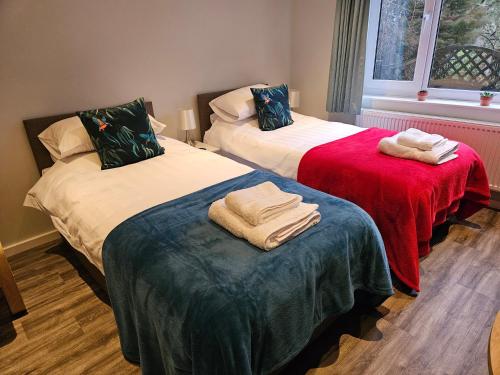 2 Betten mit Handtüchern darüber in einem Zimmer in der Unterkunft Level 15 Accommodation in Buxton