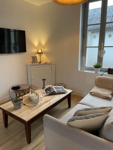 a living room with a coffee table and a couch at Maison Les 3 oies in Le Crotoy