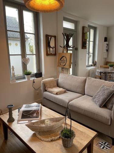 a living room with a couch and a coffee table at Maison Les 3 oies in Le Crotoy
