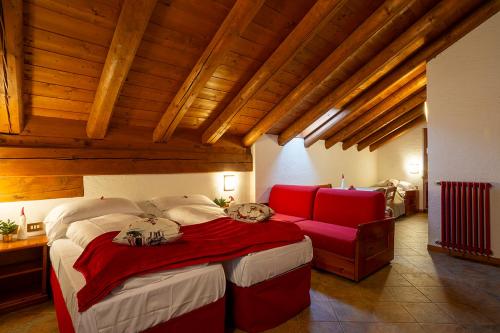 1 dormitorio con 1 cama grande y 1 sofá rojo en Residence Monterosa, en Macugnaga