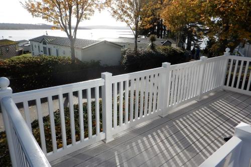 une clôture blanche sur une maison dans l'établissement Family Seaside Retreat Private Stay at 5-Star Rockley Holiday Park Poole, à Poole