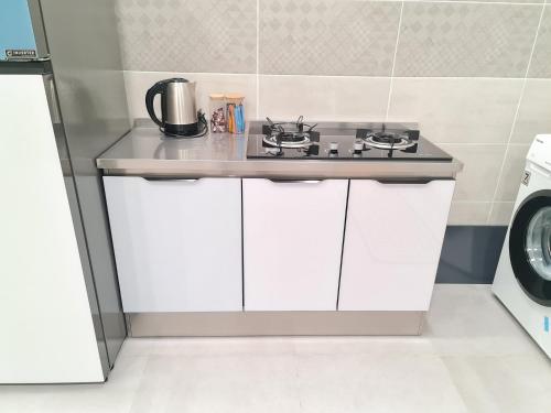 a kitchen with a counter with a stove at White Sweet Homestay, Kulim Hi-Tech Park Kedah utk MsIIim shj in Kulim