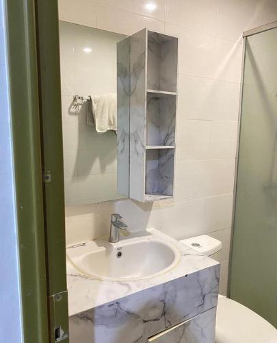 La salle de bains blanche est pourvue d'un lavabo et d'un miroir. dans l'établissement AQUTIC STAYCATION, à Wirolegi
