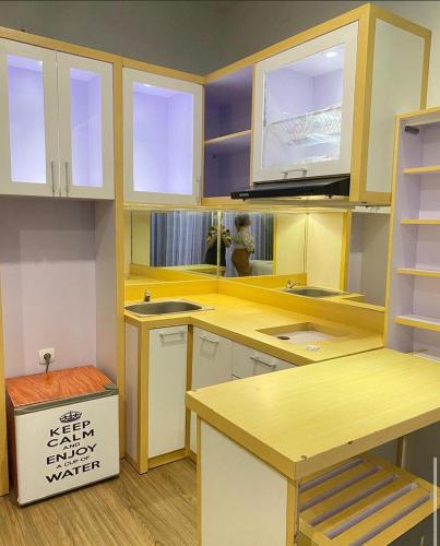 une cuisine avec des comptoirs jaunes et des armoires blanches dans l'établissement AQUTIC STAYCATION, à Wirolegi