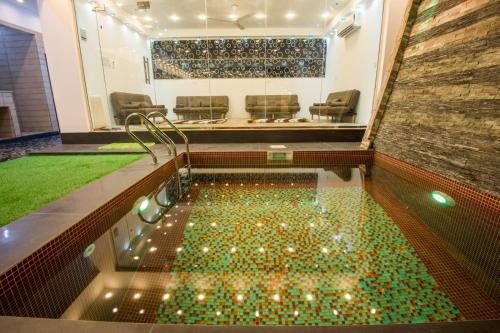ein Wasserbecken mit Lichtern in einem Zimmer mit Stühlen in der Unterkunft Munaya Chalet 2 منايا شاليه 2 in Ḩayl Āl ‘Umayr