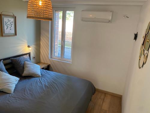 1 dormitorio con cama y ventana en Jolie petite maison solognote, en Pierrefitte-sur-Sauldre