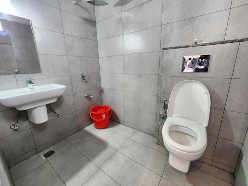 a bathroom with a toilet and a sink at Hotel ksp kings inn in Bangalore