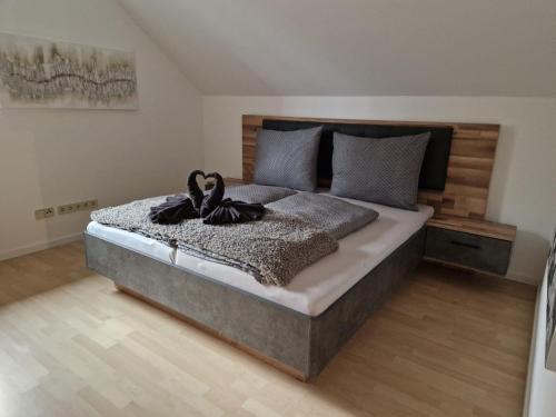 een slaapkamer met een groot bed met een houten hoofdeinde bij Aparts Lakeview -Gerlitzen -Ossiacher See -Ski in Tratten