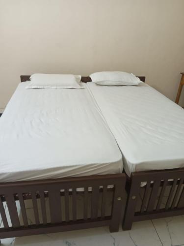 two twin beds sitting next to each other at SRI PADMANABHA TOURIST HOME in Chacka