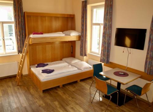 a small room with two bunk beds and a table at Junges Hotel Tulln in Tulln