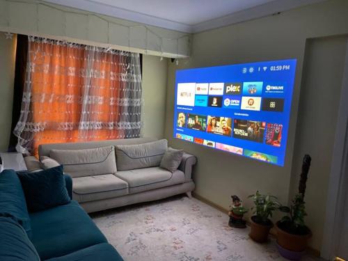 uma sala de estar com um sofá e um grande ecrã em Projeksiyonlu manzaralı daire em Duzce