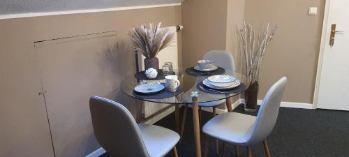 a dining room table with chairs and a glass table at Pension Kalbach by Marion in Mittelkalbach