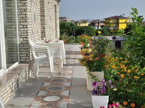 un tavolo e sedie su un patio fiorito di VILA MOZAIK a Kavajë
