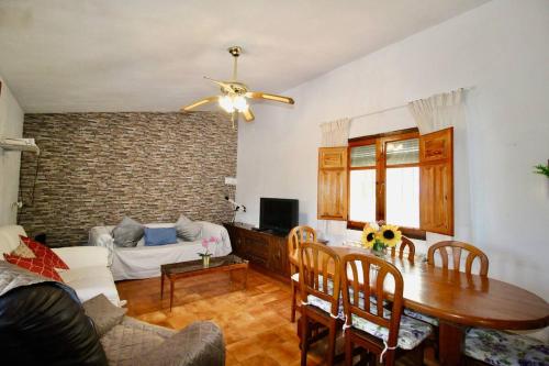 een woonkamer met een tafel en een bank bij Casa rural en naturaleza con BBQ in Villar de Cañas