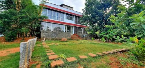 a house with a yard in front of it at Glass House - The Farm in Yelagiri