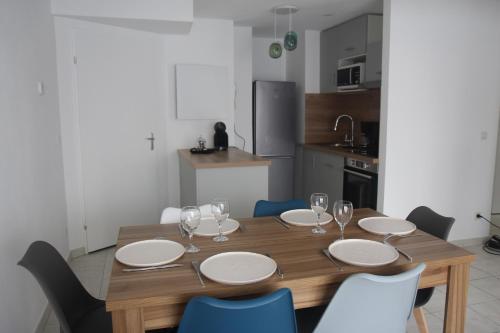 a dining room table with plates and wine glasses at Apptt rénové bien situé parking terrasse vélos in Blois