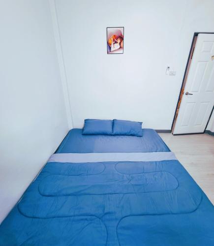 a large blue bed in a room with a door at Airport Neko House in Hat Yai