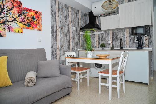 Apartamento El Sendero في البوسكي: غرفة معيشة مع أريكة وطاولة ومطبخ
