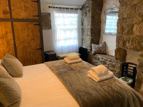 a bedroom with a bed with two towels on it at Market House, Mousehole in Mousehole