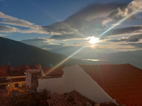 a view of the sun setting over the roofs of buildings at THOLOS HOTEL in Delfoi