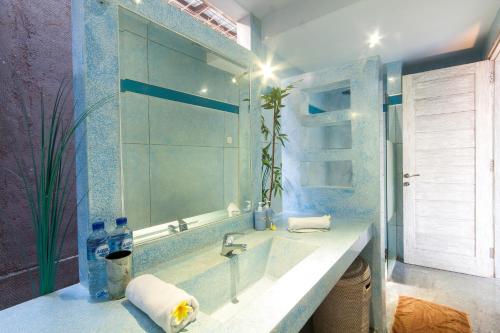 baño con lavabo y espejo grande en Villa Jalak, en Seminyak