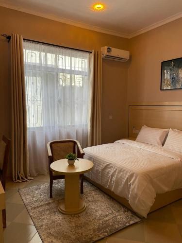 a bedroom with a bed and a table and a window at Rosa Hotels in Dodoma