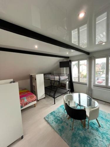 - un salon avec une table en verre et un lit dans l'établissement Maison de Ville Complète proche Paris JO 16p, à Poissy
