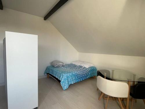 Dormitorio pequeño con cama y mesa de cristal en Maison de Ville Complète proche Paris JO 16p en Poissy